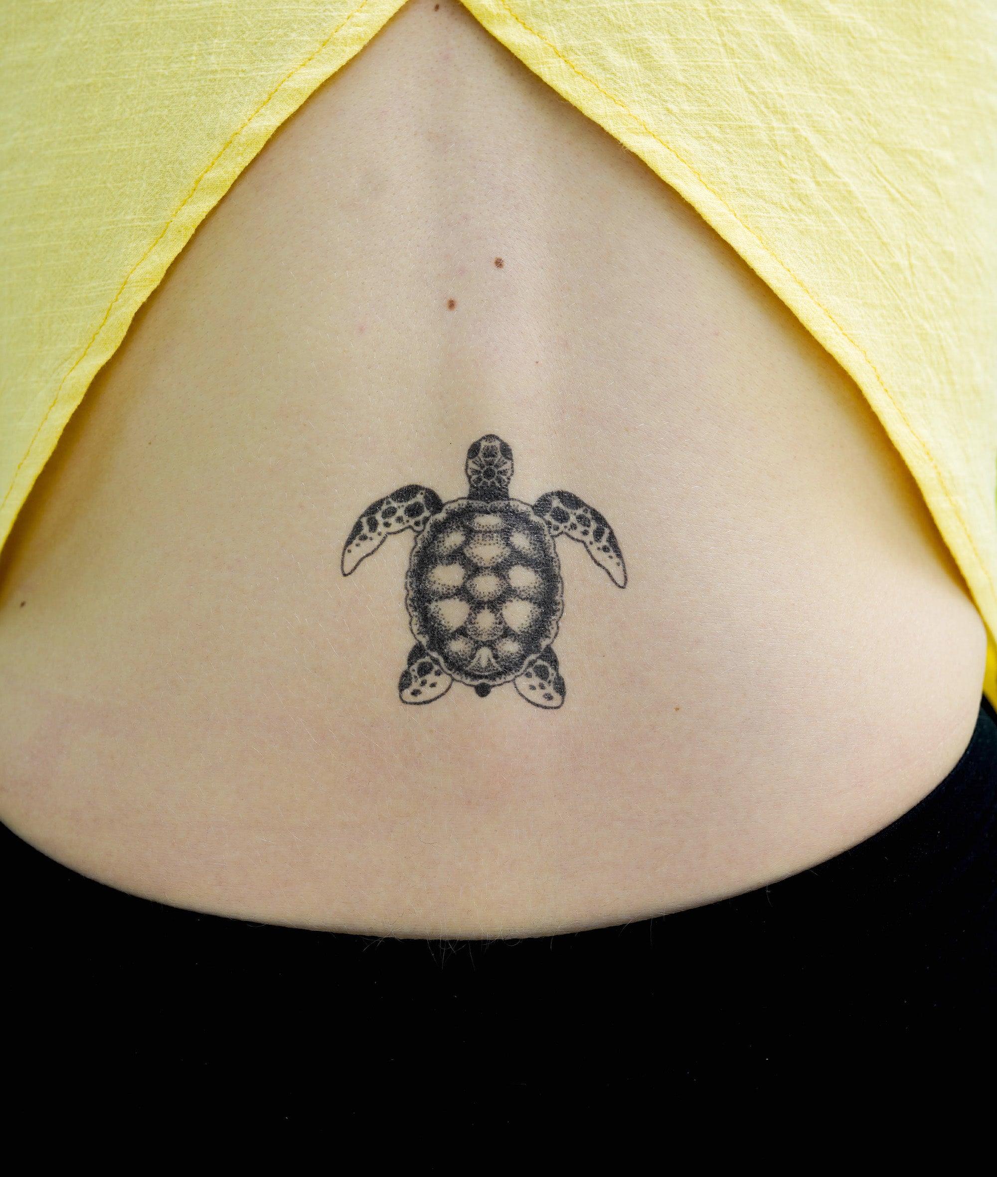 Continuous line turtle tattoo located on the bicep.