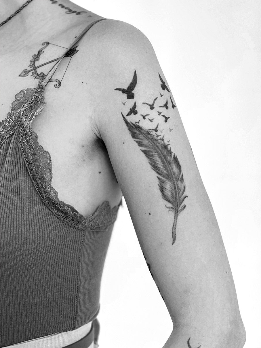 TATUAJE DE PLUMA CON PÁJAROS VOLANDO